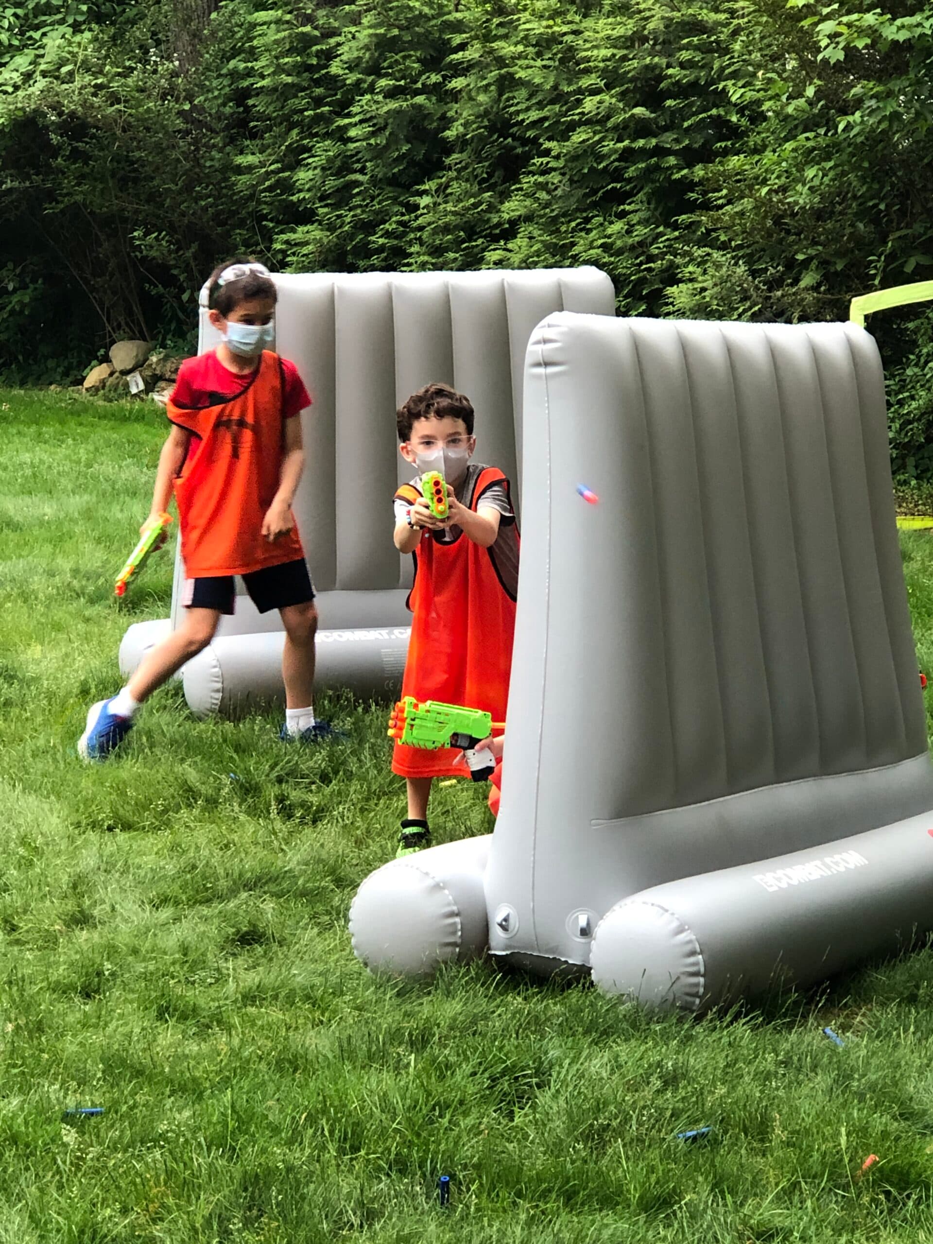 Kids battling outdoors with inflatable barriers